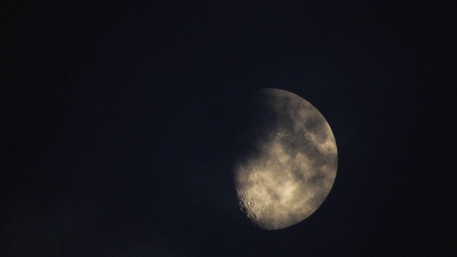 夜晚的月亮和实时的云。4k视频月亮在黑色的天空。云朵在夜晚掠过月亮。夜空阴天视频素材