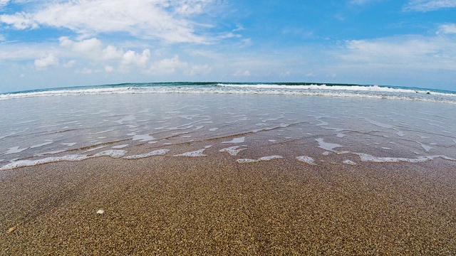 夏日蔚蓝的天空下，完美的沙滩上的印度洋波浪视频素材