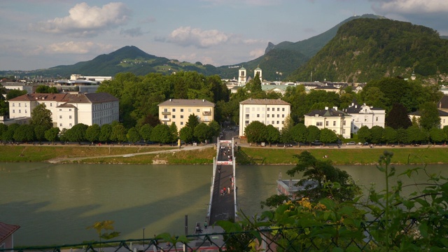 日落时分萨尔斯堡市中心河流人行桥慢镜头全景4k奥地利视频素材