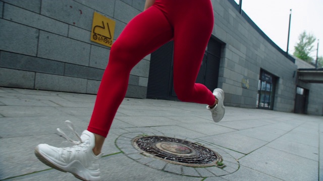 特写女性的腿跑在城市的街道上。健身女性跑完全程视频素材