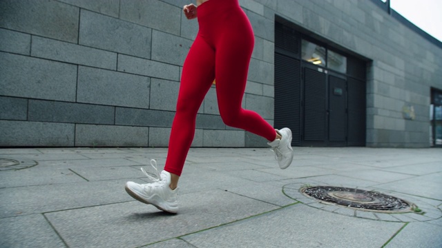 健身女人的腿跑在城市的街道上。近距离跑女人的腿慢跑视频素材