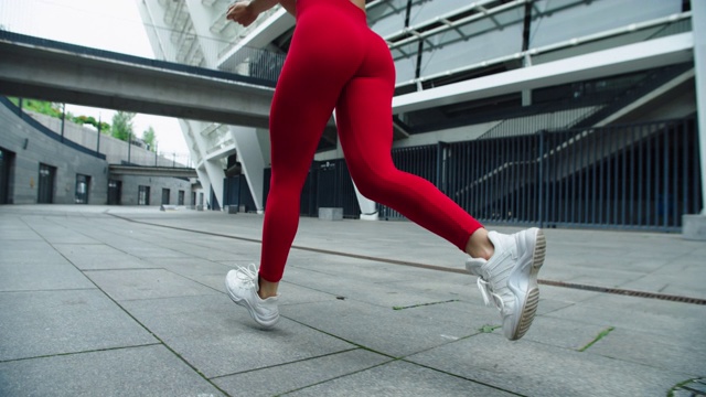 特写女性的腿跑在城市的街道上。健身女性户外跑步训练视频素材