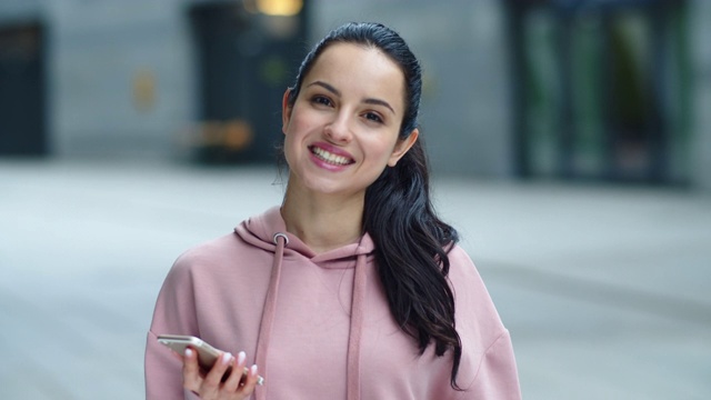 特写年轻女子看手机。快乐的女孩看着镜头视频素材