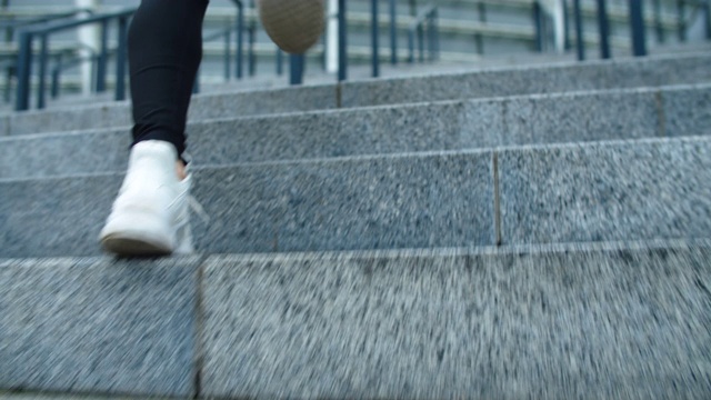 近距离适合女人的腿跑户外。特写女性的脚跑上楼梯视频素材