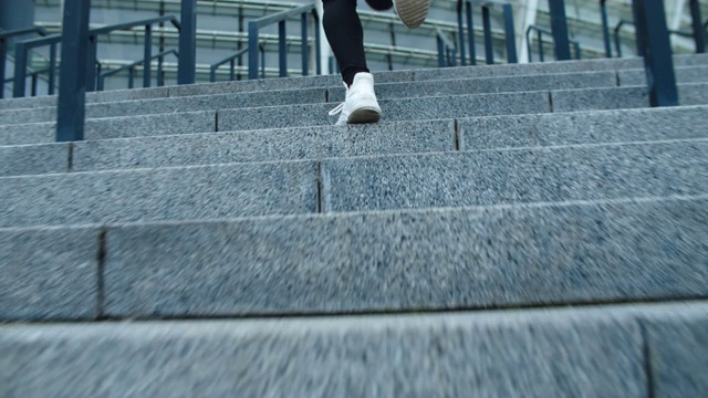 特写女性的腿跑上室外楼梯。健身女孩上楼了。视频素材