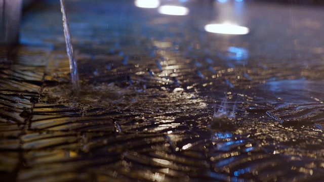 特写雨落在城市街道与地面灯在晚上视频素材