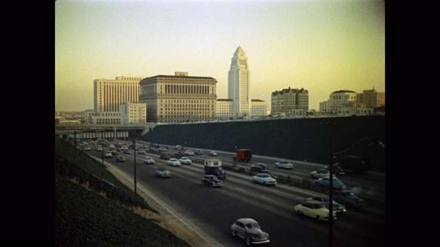 20世纪50年代的交通在高速公路上行驶，以洛杉矶市政厅为背景，美国加利福尼亚州洛杉矶视频素材