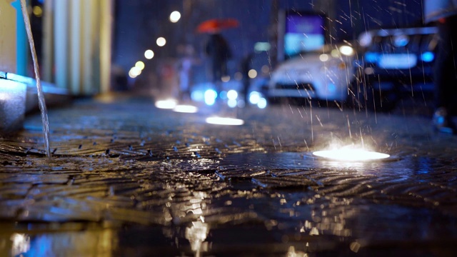 雨在城市街道上的慢动作与地面灯在夜晚视频素材