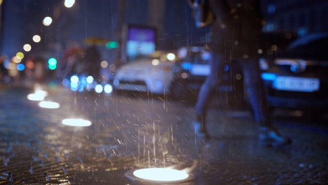 雨在城市街道上的慢动作与地面灯在夜晚视频素材