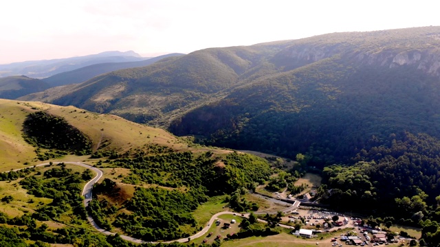 航空。被茂密的绿色针叶林遮蔽的山的全景。靠近大峡谷入口的汽车公路，图尔达峡谷，克卢日县，罗马尼亚，欧洲，特兰西瓦尼亚，喀尔巴阡视频素材