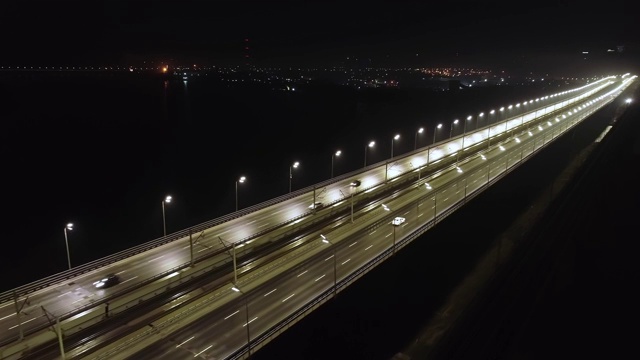 灯火通明的夜城桥上，繁忙的交通。航空摄影视频素材