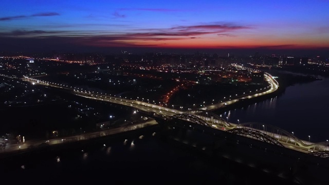 4 k的视频。城市上空是黎明，汽车在桥上行驶。太阳从城市上空升起。航空摄影视频素材