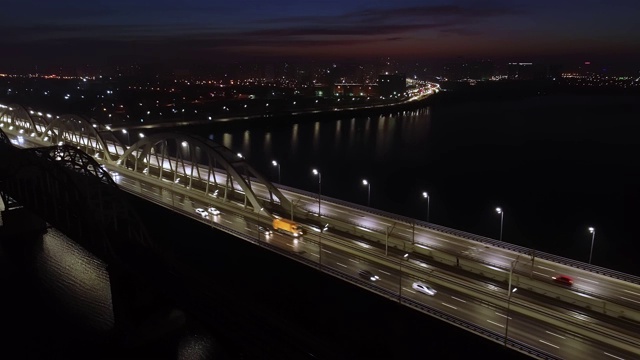 4 k的视频。城市上空是黎明，汽车在桥上行驶。太阳从城市上空升起。航空摄影视频素材