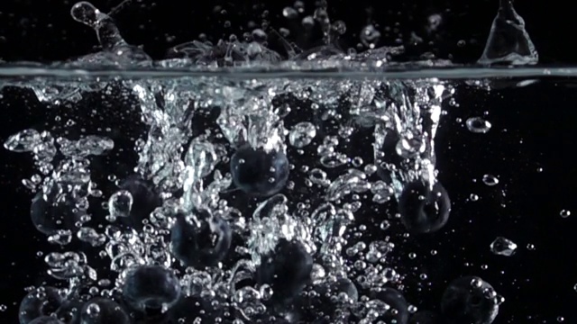超级慢动作:蓝莓滴入淡水在黑色背景视频素材