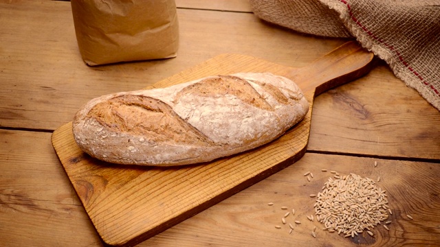 美味的自制黑麦面包在木板上与黑麦谷物从桌子上方拍摄视频素材