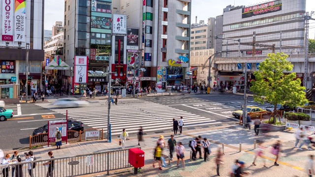 4K延时:鸟瞰东京上野美代子市场的行人拥挤的十字路口和火车行驶。视频素材