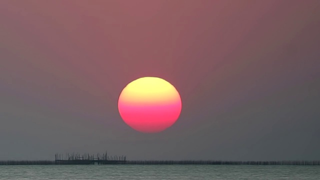 日出在红色的晴朗的天空在浅橙色的云在海上时间流逝视频素材