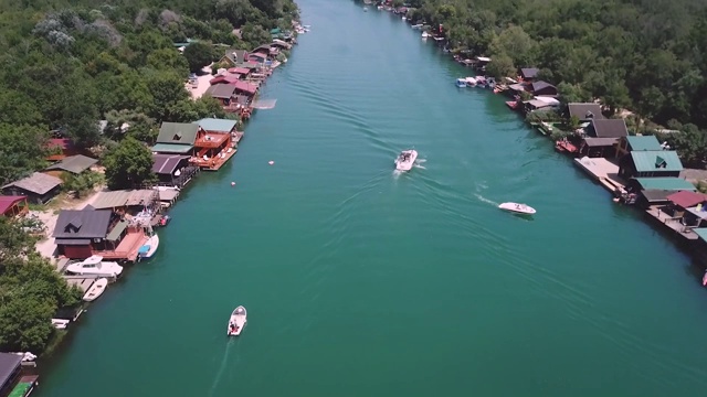 无人机观看不同的船只在一条河和平房在Bojana河的海岸线视频素材