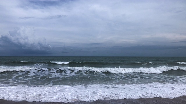 海浪冲击着热带沙滩，天空阴云密布视频下载