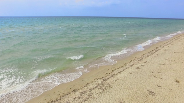 宽敞的沙滩，空旷的海滩和海浪在美丽的晴天-无人机镜头视频素材