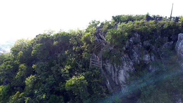 空中青翠，山上有楼梯，爬着女孩的身影视频素材