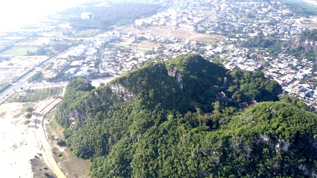 鸟瞰苍翠的山峦与庙宇相映衬的现代都市视频素材