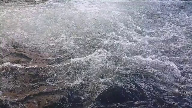 由于山区河流的快速流动，水迅速流向水中，形成泡沫和气泡视频素材