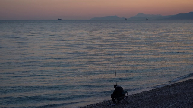 夕阳西下，海边有人垂钓视频素材