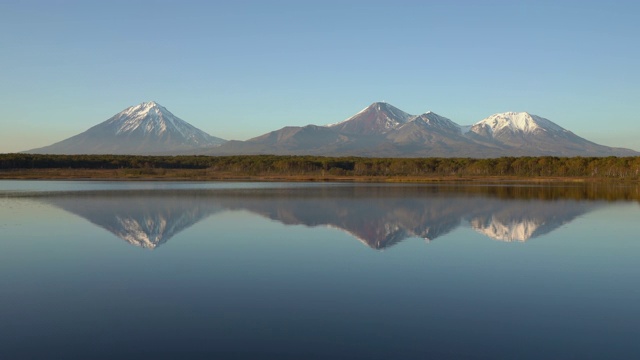 全景式的秋季火山景观-黄橙色森林和山上湖泊的倒影火山视频素材