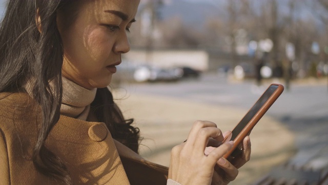 一名女子在寒假期间用智能手机给朋友发短信视频素材