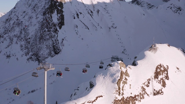 从飞行的无人机滑雪电梯在山区度假胜地令人惊叹的景色。在滑雪胜地乘坐滑雪缆车的人。无人机观看雪山度假村。冬季运动的概念。视频素材