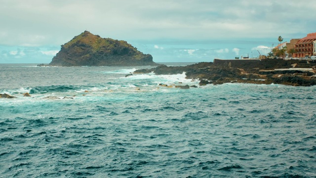 加那利群岛西部的海湾。大海里的一块大石头，海浪拍打着石头，溅起白色的泡沫。Garachico、西班牙视频素材