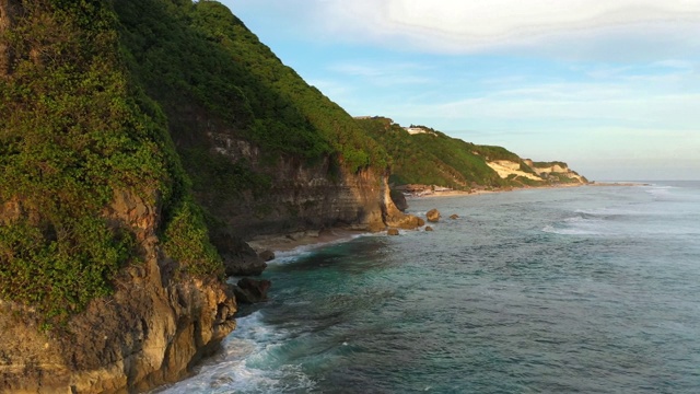 乌鲁瓦图的日落——海洋和岩石山，覆盖着热带树木。从上面的观点视频素材