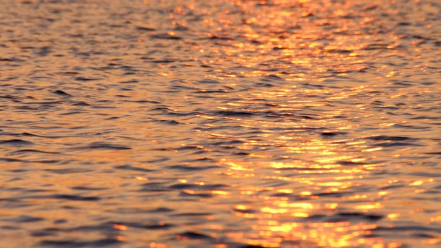 海水背景。大海上的小波浪。海面背景。平静的海水。月亮倒映在水面上。夕阳的光倒映在水面上。冥想的概念。岩浆颜色调色板。视频素材