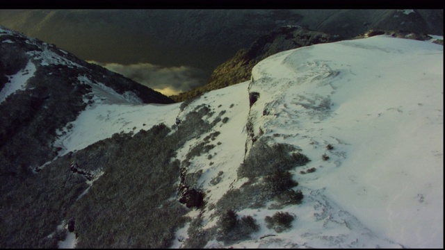 登山运动员横越白雪覆盖的高山腰。视频素材