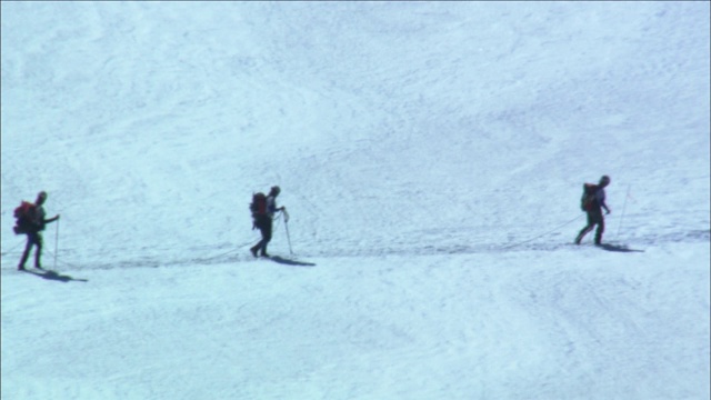 一支登山队徒步穿越积雪的冰川。视频素材