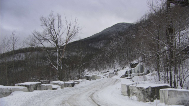 在佛蒙特州的一条山路上，铺满了积雪的花岗岩。视频素材