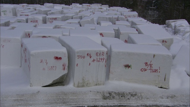 在佛蒙特州的一个采石场，雪花将花岗岩的块状物吹散。视频素材