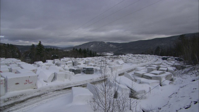 在佛蒙特州，一块块花岗岩填满了一个积雪的采石场。视频素材