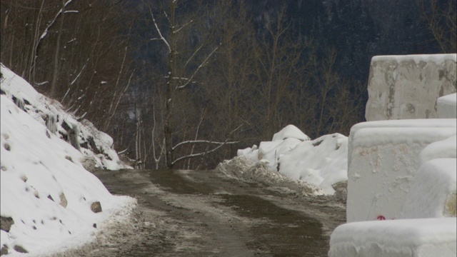 在佛蒙特州，一块块的花岗岩排列在一条积雪的山路上。视频素材