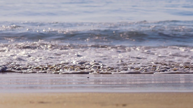 轻柔的海浪从大海来到潮湿的沙滩。视频素材