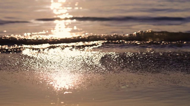 4K超高清日落海滩波从海到海滩与阳光反射在水海软焦点和焦点选择性软波和沙子。视频素材