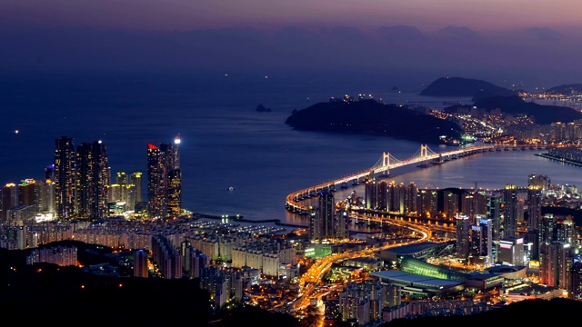 韩国釜山，Suyeong-gu, Haeundae, Gwangandaegyo大桥和市中心/海云台的日落夜景视频素材