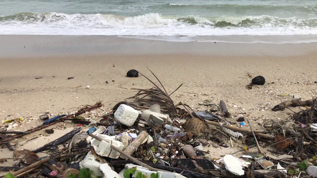 沙滩和海浪上的塑料垃圾视频下载