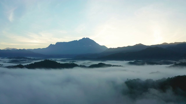 4K航拍镜头令人惊叹的美丽的自然景观，在日出与最大的基纳巴卢山与雾在沙巴州，婆罗洲农场视频素材