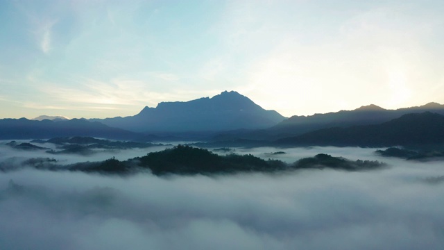 4K航拍镜头令人惊叹的美丽的自然景观，在日出与最大的基纳巴卢山与雾在沙巴州，婆罗洲农场视频素材