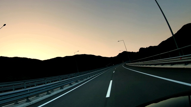 运动快速pov驾驶在空旷的沥青公路和日落天空的背景视频素材