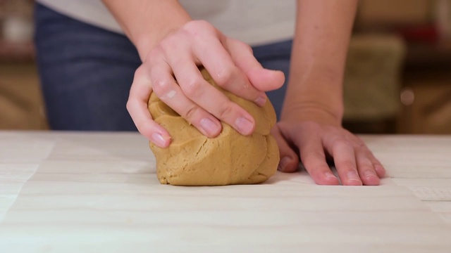 女人在厨房的桌子上用手揉面视频素材