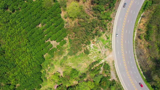 鸟瞰图，弯曲的道路通过森林与汽车移动。火箭。视频素材