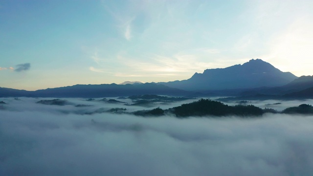 4K航拍镜头令人惊叹的美丽的自然景观，在日出与最大的基纳巴卢山与雾在沙巴州，婆罗洲农场视频素材